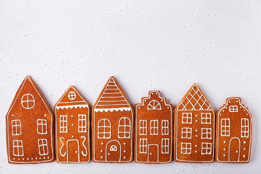 Gingerbread Cookies In The Shape Of Houses On A White Stone Background
