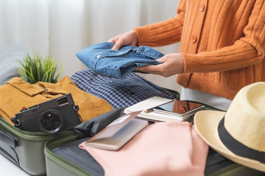 A Woman Packing Clothes For A Trip