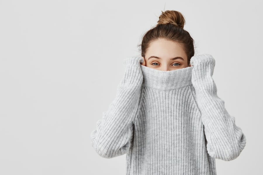 Portrait Of Girl Pulling Her Trendy Sweater Over Head Having Fun.