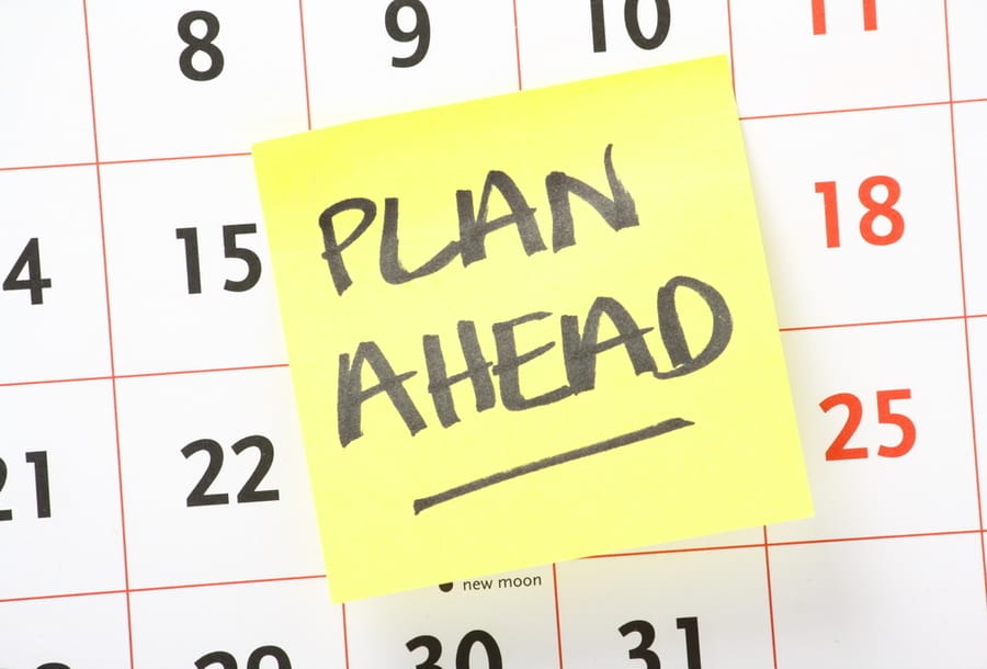 The Phrase Plan Ahead Written On A Yellow Sticky Paper Note And Stuck On A Wall Calendar Background