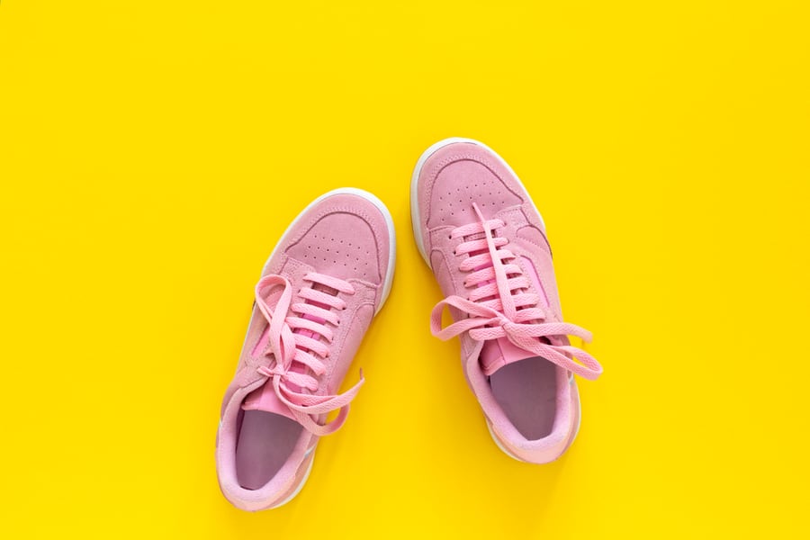 Pink Nubuck Sneakers Isolated On A Yellow Background, Seasonal Shoes For Walking And Sports, Top View