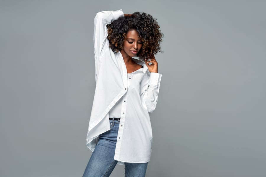 African American Woman With Afro Hairstyle Wear White Loose Shirt Isolated On Gray Background