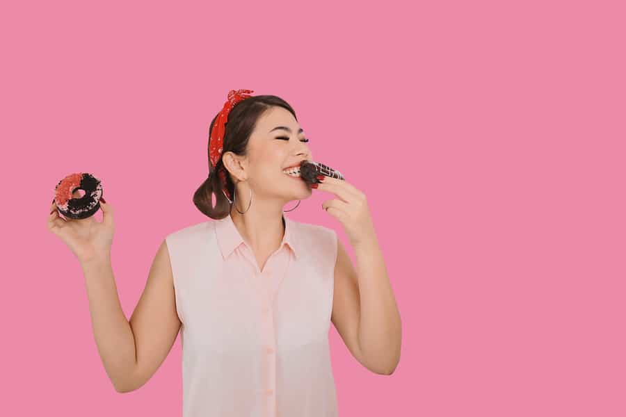 Beautiful Girl Holding Delicious Sweet Donut An Having Fun Isolated On Pink Background.