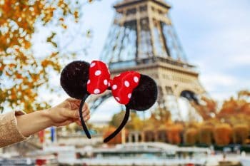 Closeup On Minnie Mouse Ears In Female Hand On Embankment Near Eiffel Tower In Paris