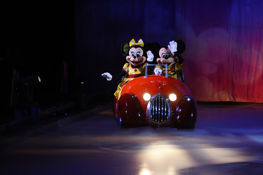Disney Characters Mickey Mouse And Minnie Mouse Riding In A Car At Disney