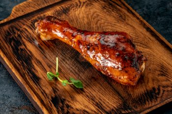 Drumstick Chicken Leg In Barbecue Sauce On A Wooden Chopping Board