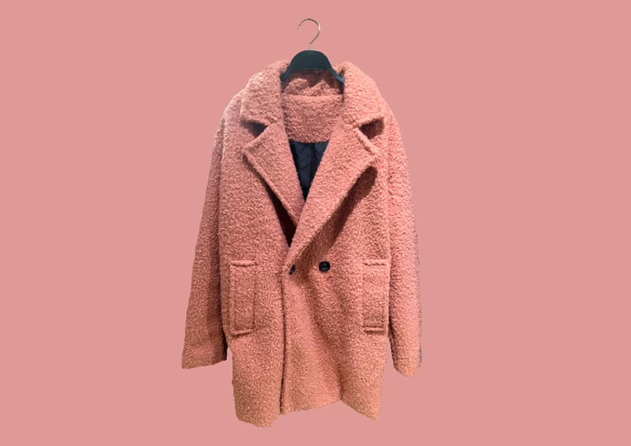 Fashionable Pink Women Faux Shearling Coat On A Hanger Isolated On Pink Background.