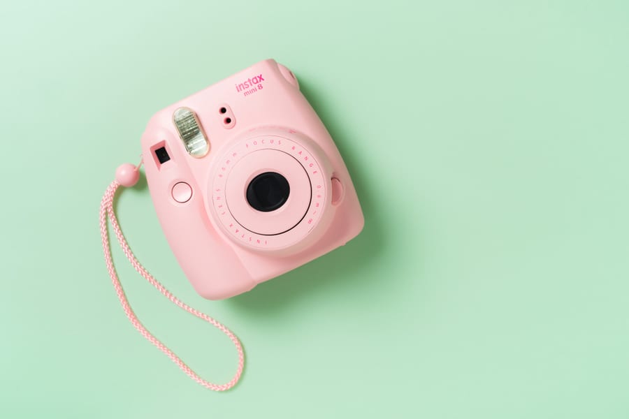 The Pink Fujifilm Instax Mini 8 Instant Camera On Green Background