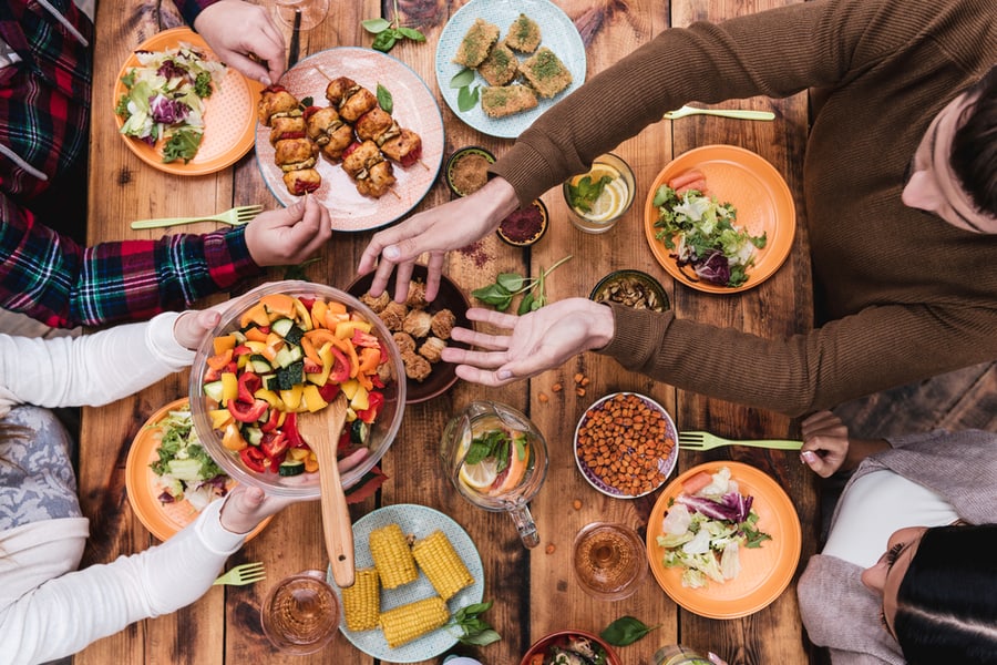 Top View Of Four People Having Dinner Together While Sitting At The Rustic Wooden Table