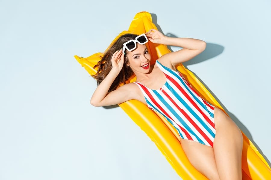 Woman Slim Body Wear Striped One-Piece Swimsuit Sunglasses Lies On Inflatable Mattress