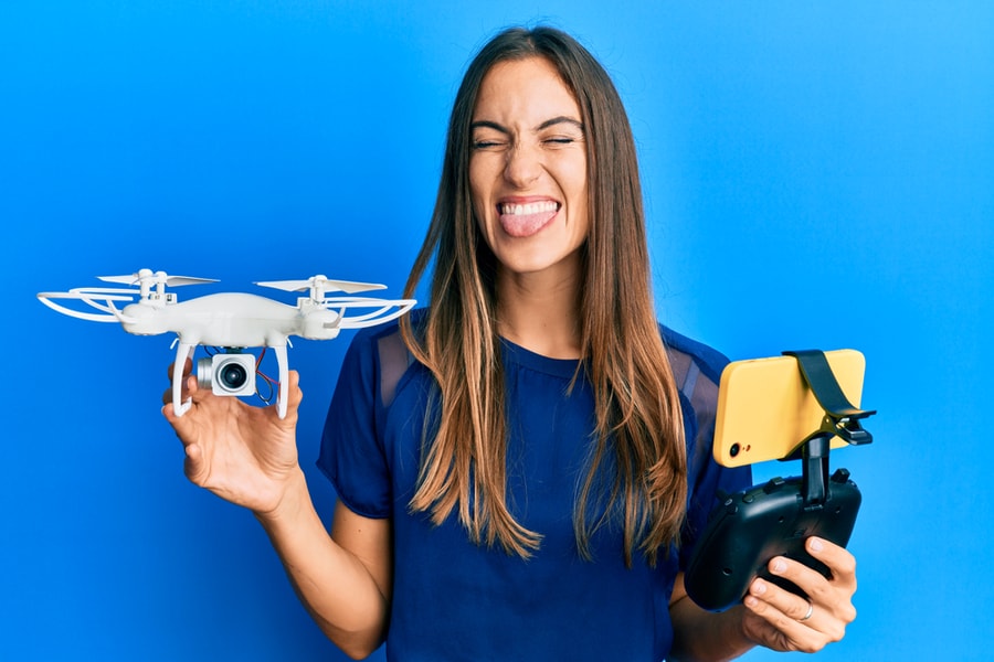 Young Beautiful Woman Taking A Selfie Photo With Smartphone Flying Drone Sticking Tongue